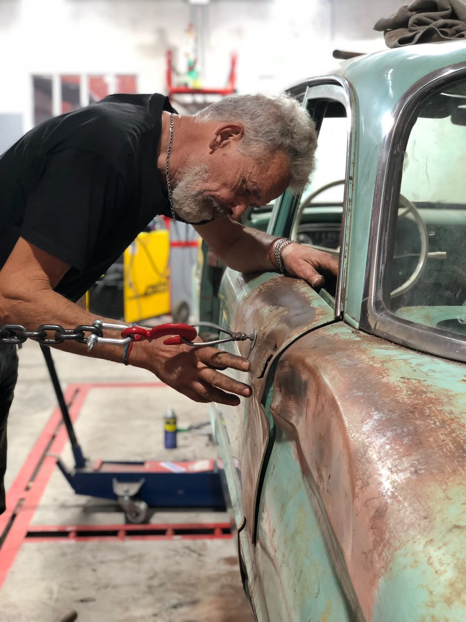 Roberto Scenna trabajando la chapa de un auto clasico en su taller